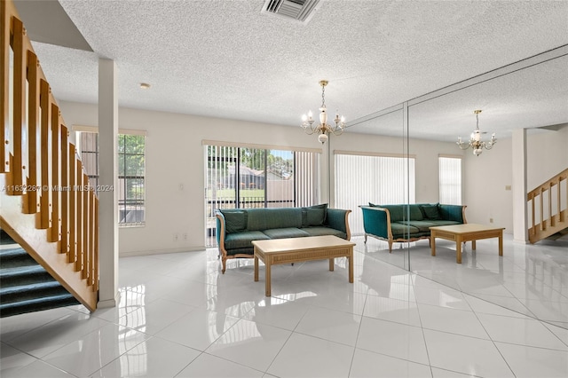 living room featuring a notable chandelier, light tile patterned floors, and a textured ceiling