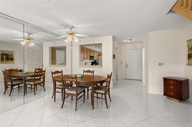 tiled dining room with a textured ceiling and ceiling fan