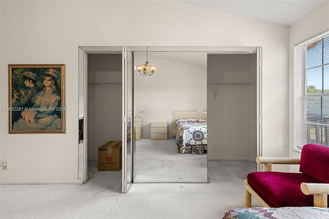 bedroom featuring a chandelier, a closet, lofted ceiling, and carpet flooring