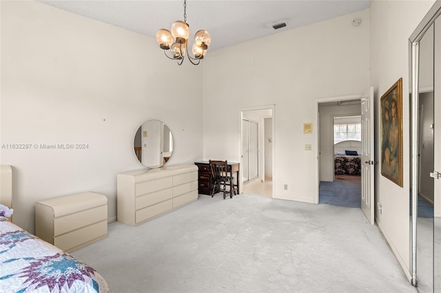 bedroom featuring a towering ceiling, a notable chandelier, and light colored carpet