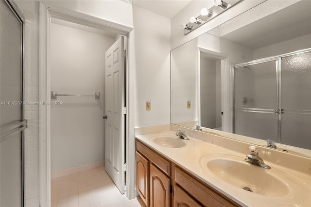 bathroom featuring dual vanity, walk in shower, and tile patterned flooring