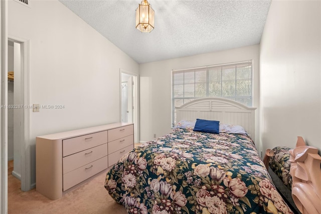 bedroom with lofted ceiling, carpet floors, and a textured ceiling