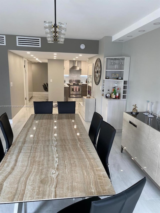 dining area with a chandelier and light tile patterned flooring