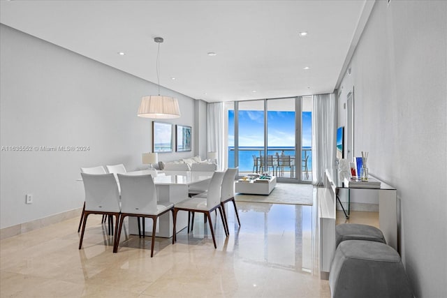 dining room featuring floor to ceiling windows, a water view, and light tile patterned floors