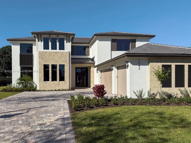 prairie-style house with a garage and a front lawn