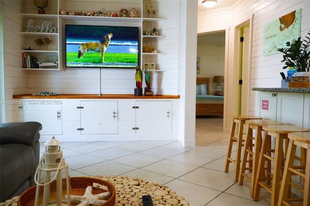 living room featuring ceiling fan, light tile patterned flooring, wooden walls, and wooden ceiling