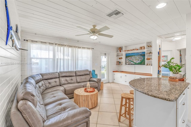 living room featuring wood ceiling, a healthy amount of sunlight, visible vents, and light tile patterned flooring