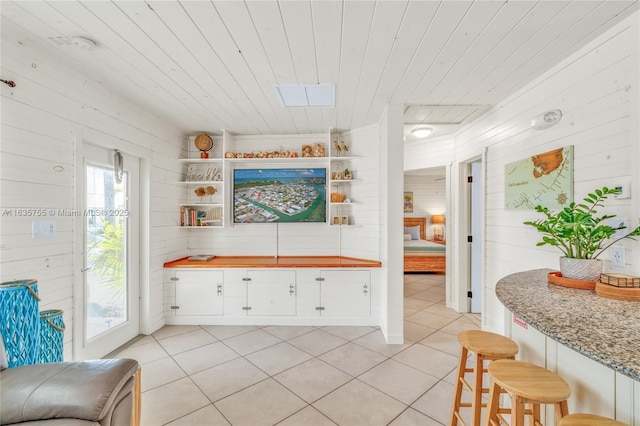 mudroom featuring light tile patterned floors, wood ceiling, and wooden walls