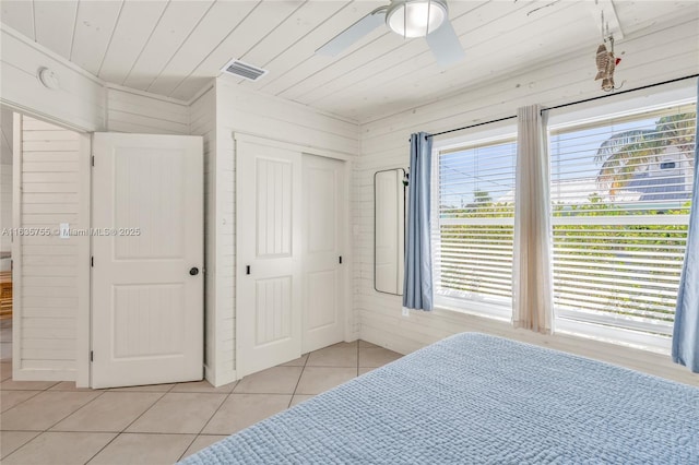 bedroom with light tile patterned floors, ceiling fan, wooden ceiling, visible vents, and a closet