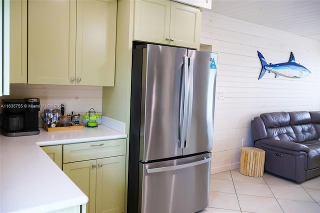 kitchen featuring dark stone countertops, green cabinetry, sink, wooden walls, and stainless steel appliances