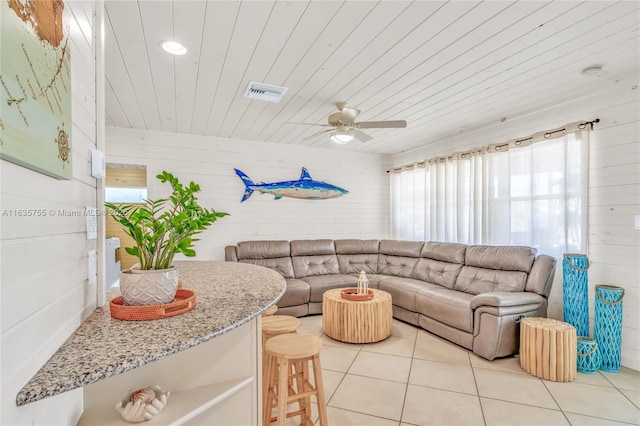 living room with wooden ceiling, visible vents, plenty of natural light, and light tile patterned floors