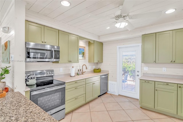 kitchen with green cabinets, stainless steel appliances, light tile patterned floors, and light countertops