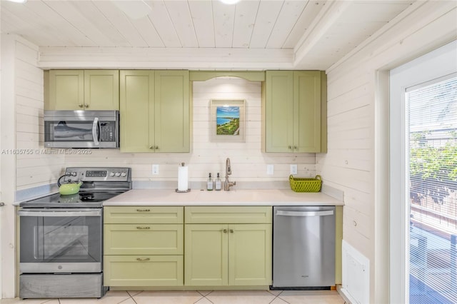 kitchen with green cabinetry, wooden ceiling, stainless steel appliances, light countertops, and a sink