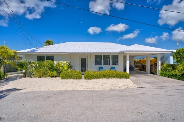 view of front of house featuring a carport, concrete driveway, and stucco siding