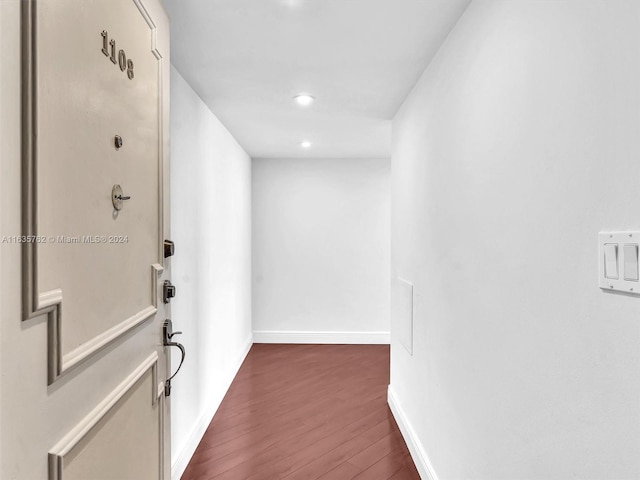 hall with recessed lighting, dark wood finished floors, and baseboards