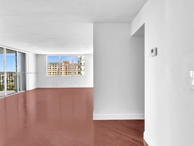 spare room featuring baseboards and wood finished floors