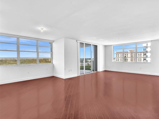 empty room featuring wood finished floors and baseboards