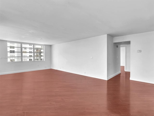 empty room featuring wood finished floors and baseboards