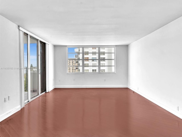 empty room featuring baseboards and wood finished floors