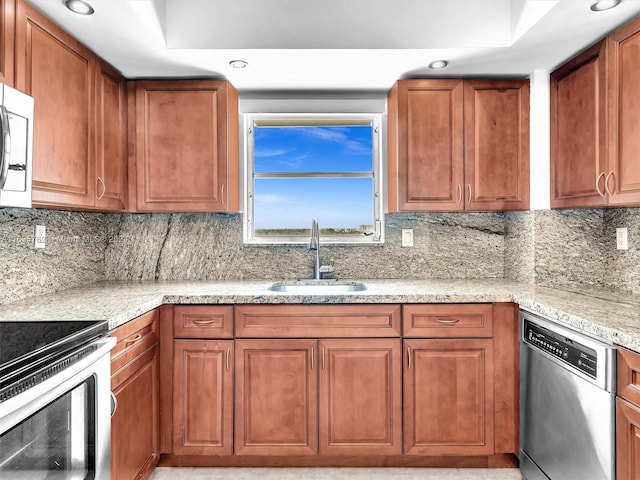 kitchen featuring light stone counters, brown cabinets, a sink, stainless steel appliances, and backsplash