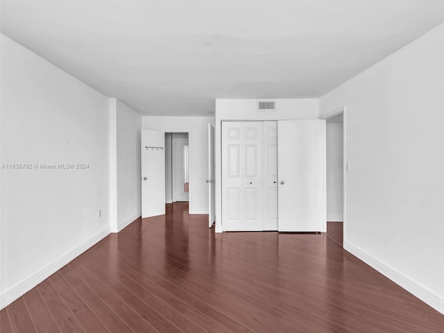 unfurnished bedroom featuring a closet, baseboards, and wood finished floors