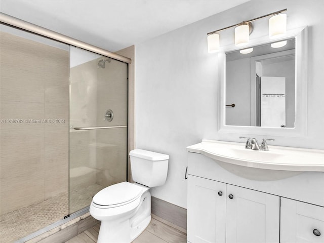 bathroom with a stall shower, vanity, and toilet