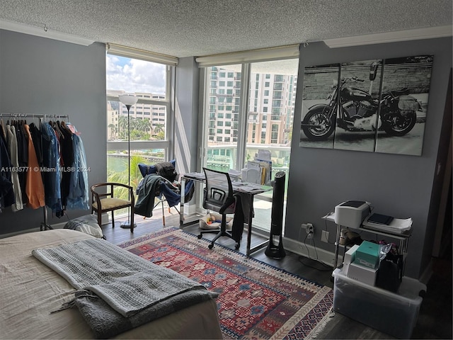 home office with a wealth of natural light, floor to ceiling windows, and hardwood / wood-style flooring