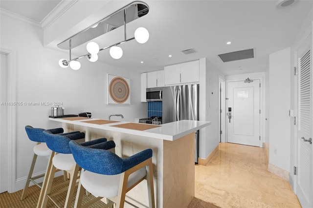 kitchen with white cabinets, light tile patterned floors, a kitchen bar, and kitchen peninsula