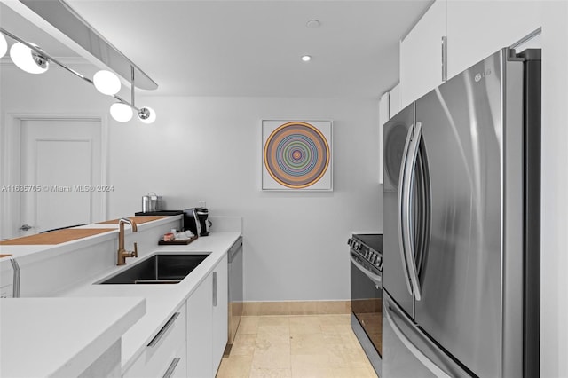 kitchen with light tile patterned flooring, sink, stainless steel appliances, and white cabinets