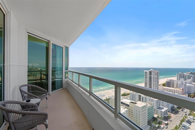 balcony featuring a water view and a view of the beach