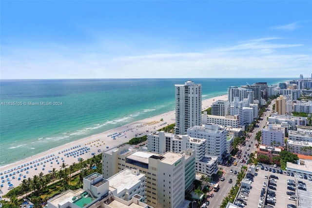 birds eye view of property with a water view and a beach view