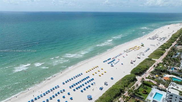 drone / aerial view featuring a beach view and a water view