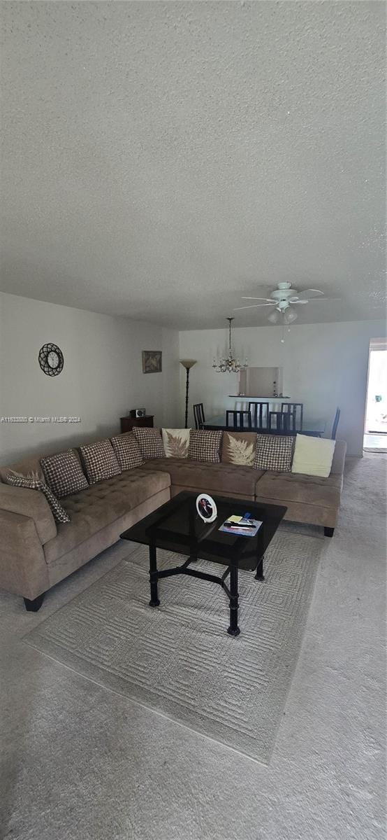 living room with carpet floors, a textured ceiling, and ceiling fan