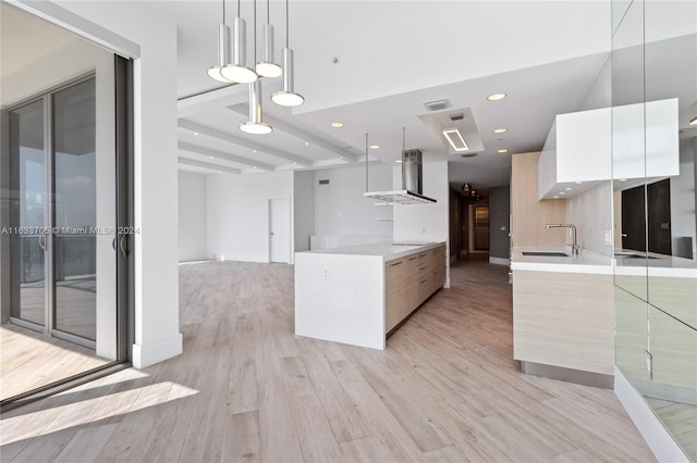 kitchen featuring island range hood, white cabinets, modern cabinets, light countertops, and pendant lighting