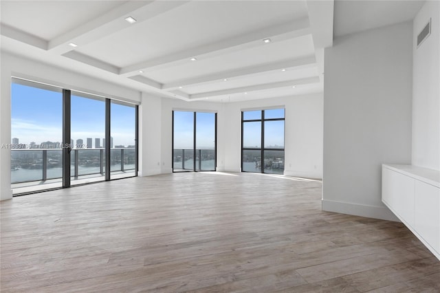 spare room featuring visible vents, baseboards, light wood-style flooring, a water view, and recessed lighting