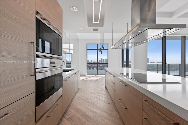 kitchen featuring modern cabinets, island exhaust hood, and light countertops