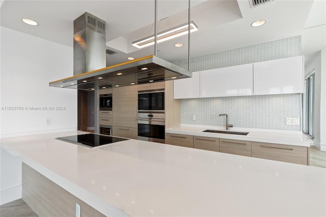 kitchen with black appliances, modern cabinets, white cabinetry, and light countertops