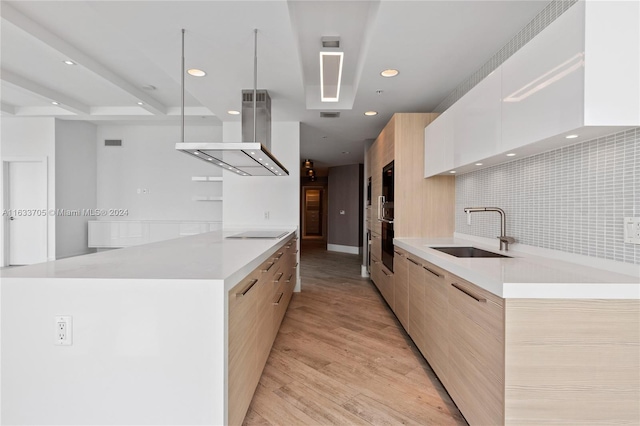 kitchen with white cabinets, light countertops, a sink, and modern cabinets