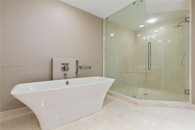 bathroom featuring a soaking tub, a shower stall, and baseboards