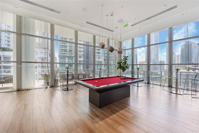 rec room with billiards, visible vents, wood finished floors, expansive windows, and a city view