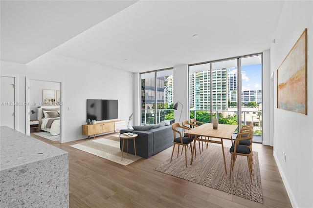 dining space featuring hardwood / wood-style flooring and a wall of windows