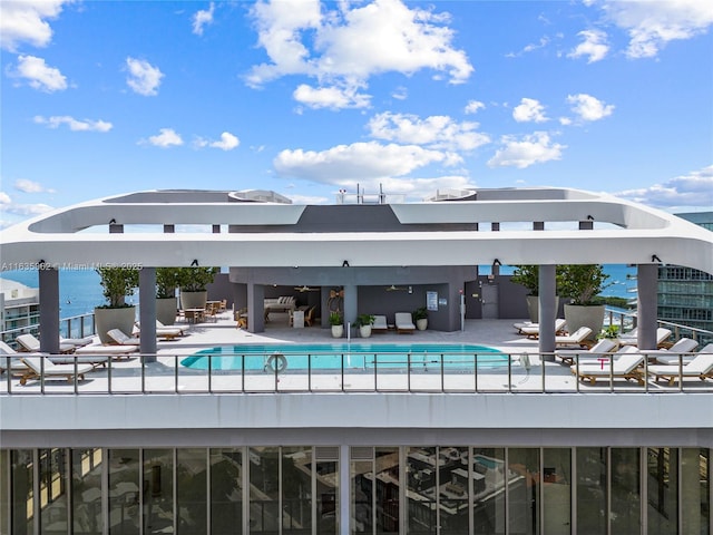 view of swimming pool with a water view and a patio