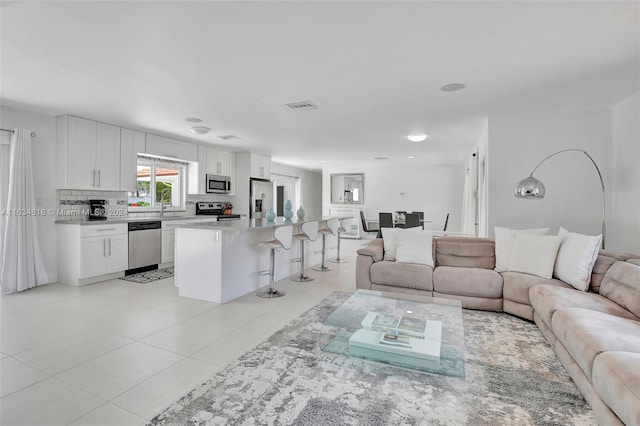 tiled living room featuring sink