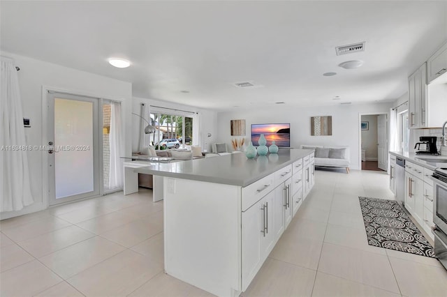 kitchen with light tile patterned floors, stainless steel appliances, and white cabinetry