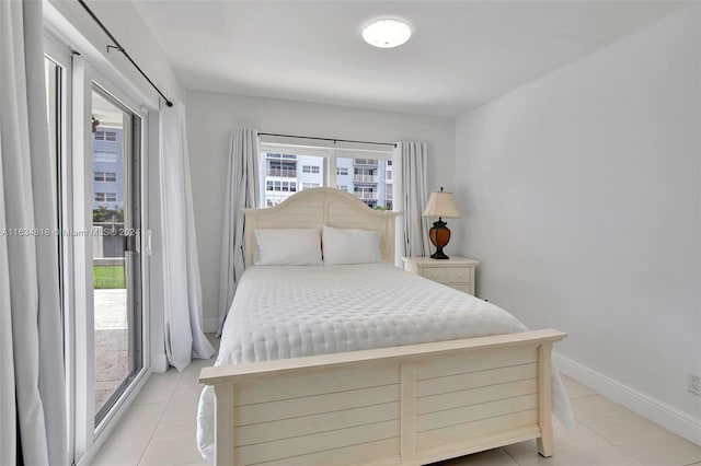 tiled bedroom with multiple windows and access to exterior