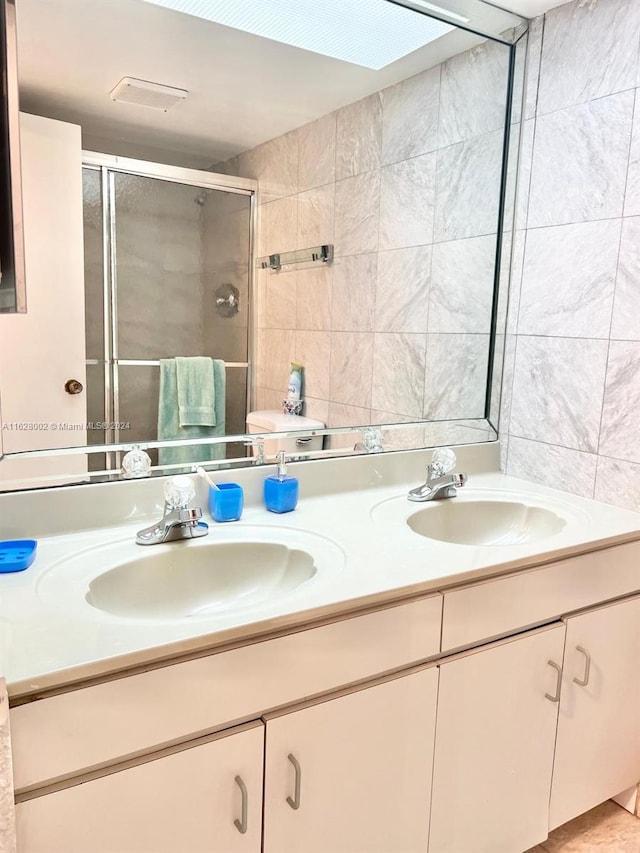 bathroom with a shower with door and vanity