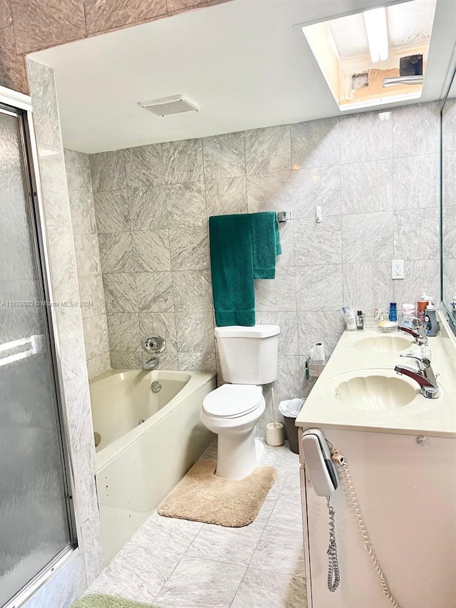 full bathroom with independent shower and bath, tile walls, toilet, vanity, and tile patterned floors