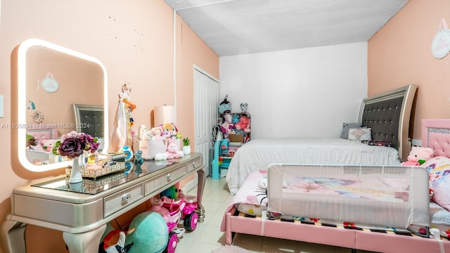 bedroom with light tile patterned flooring and a closet