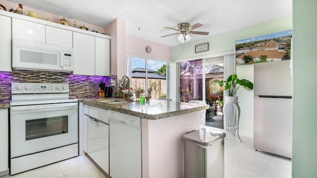 kitchen with white appliances, light tile patterned floors, decorative backsplash, white cabinetry, and ceiling fan