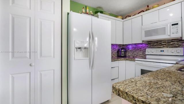 kitchen with decorative backsplash, a textured ceiling, white appliances, and white cabinets